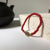 Handmade Red Beaded Bracelet, Green Accents, Floral Centerpiece Playful Boho Jewelry